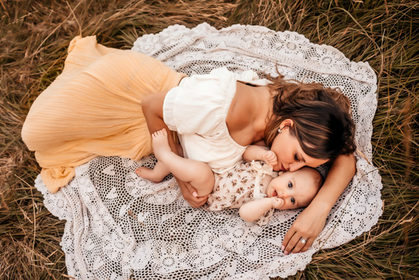 Family Photography, mom laying with baby on a lace blanket