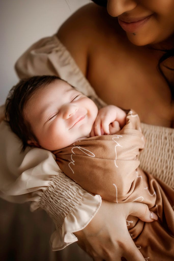 Newborn Photographer, a baby sleeps in mother's arms